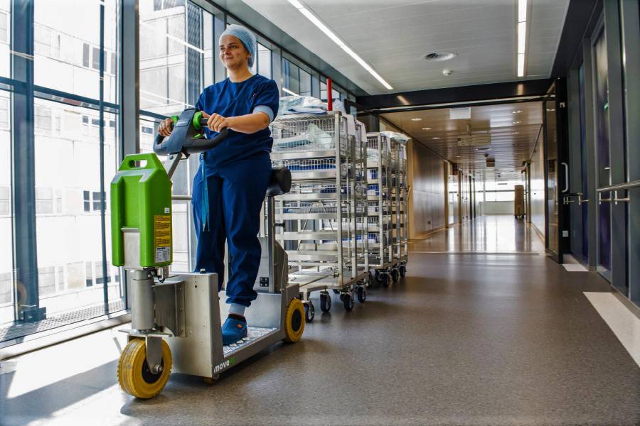 elektrický tahač movexx rr1000-s pro stojícího řidiče, manipulace vozíků ve vláčku za sebou v nemocnici